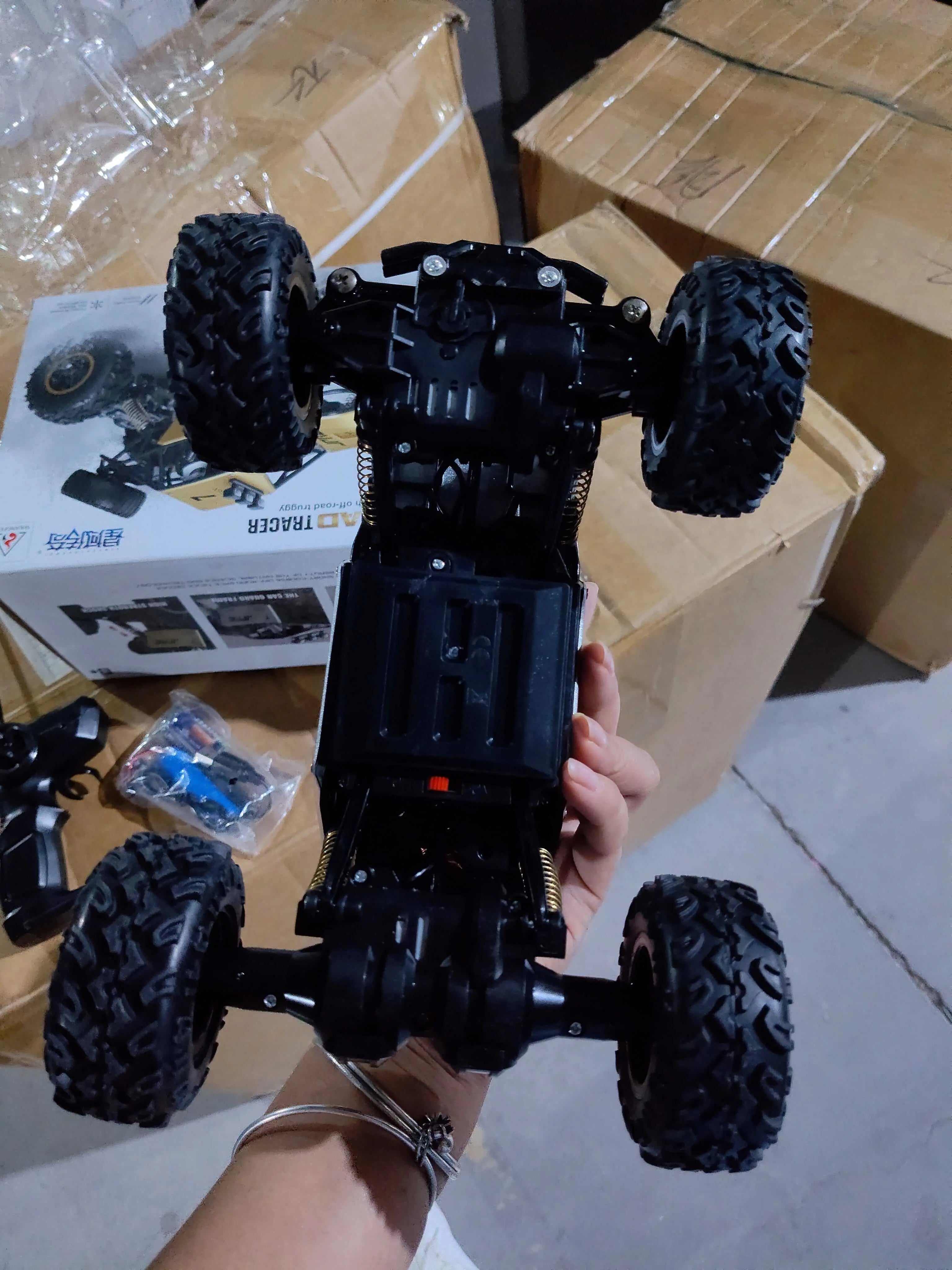 4WD RC Car off-road buggy chassis with large tires held in hand