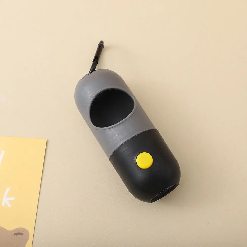 Gray and black device with a yellow button on a beige background