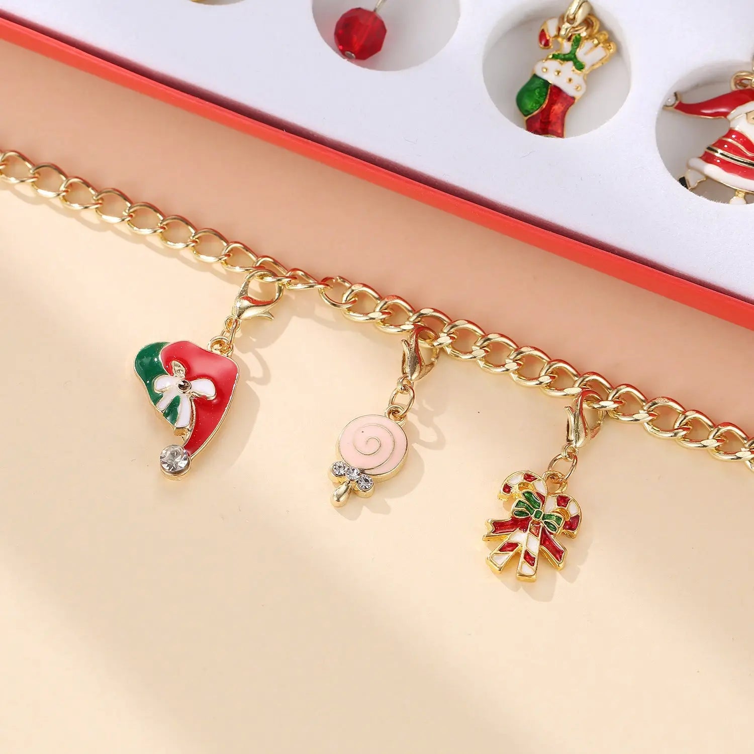 Children’s charm bracelet with gold chain and Christmas-themed enamel charms from advent calendar set