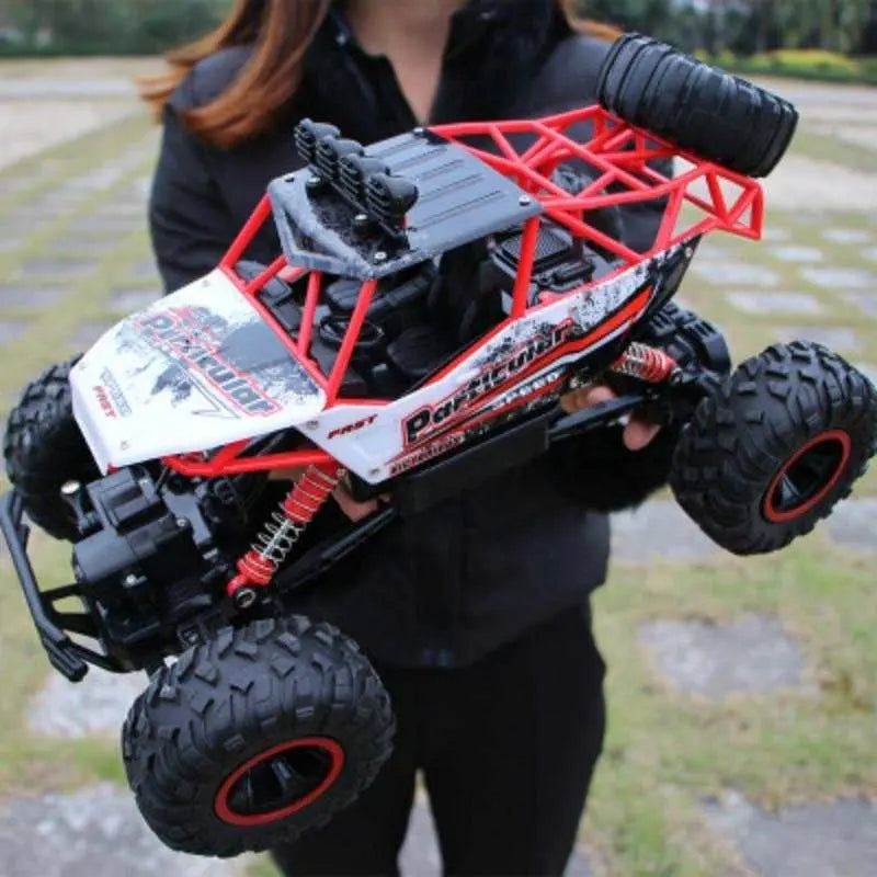 1:12 scale 4WD RC off-road climbing truck with red frame and large tires held by person
