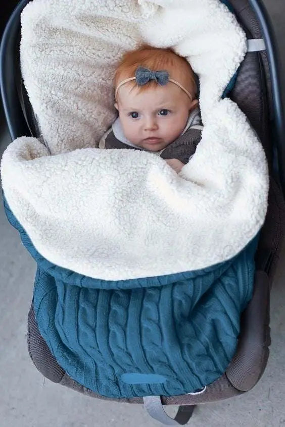 Baby wrapped in luxury winter baby buggy sleeping bag with lamb cashmere lining in teal color