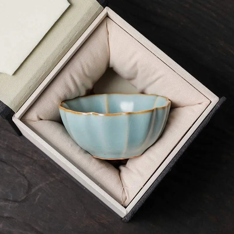 Traditional Chinese ceramic teacup in cushioned gift box with blue glaze and gold rim detailing