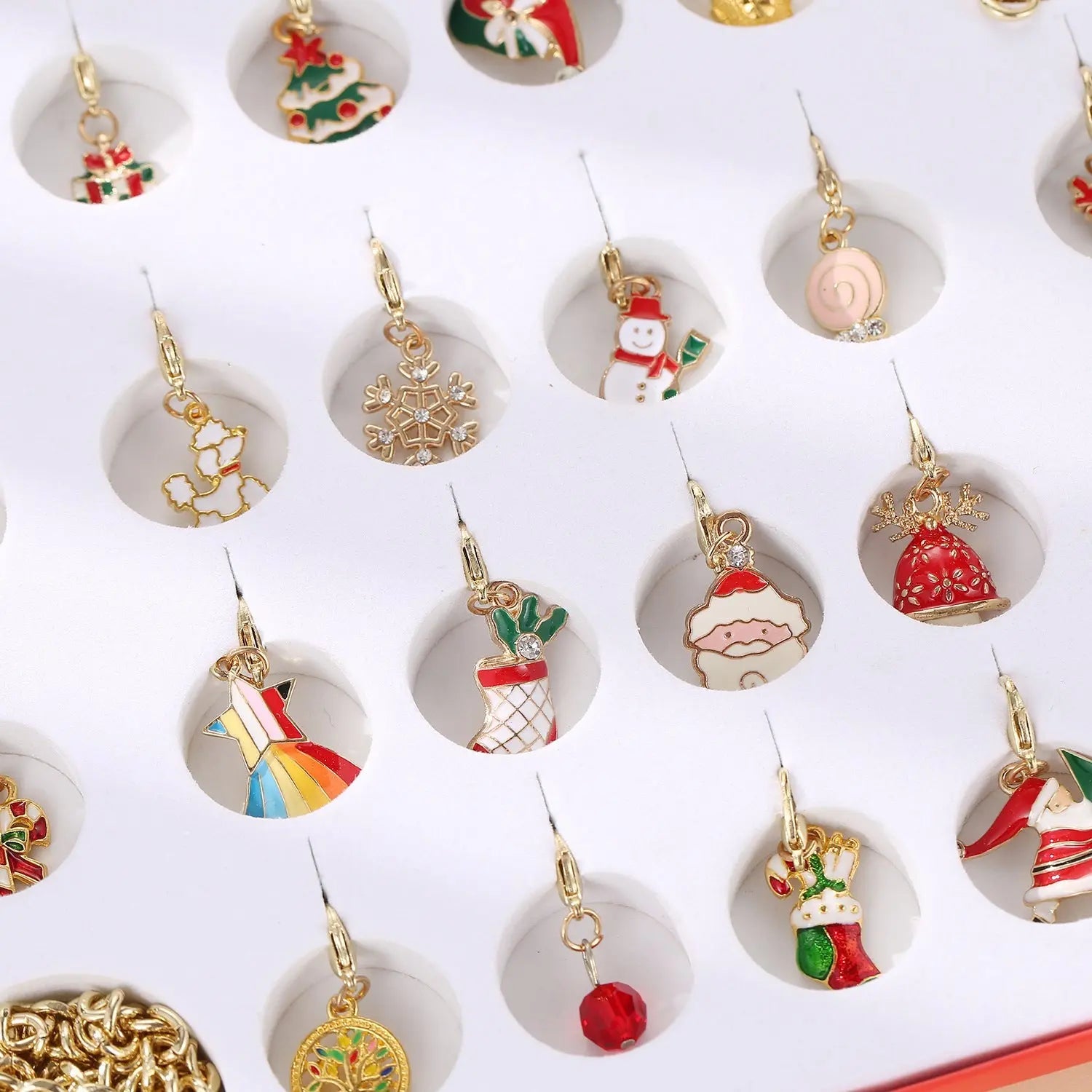 Children’s charm bracelet and necklace advent calendar with 24 festive Christmas-themed blind box charms in gold alloy for kids.
