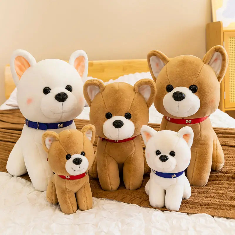 Group of adorable plush puppy stuffed toys in various sizes and colors with collars on bed