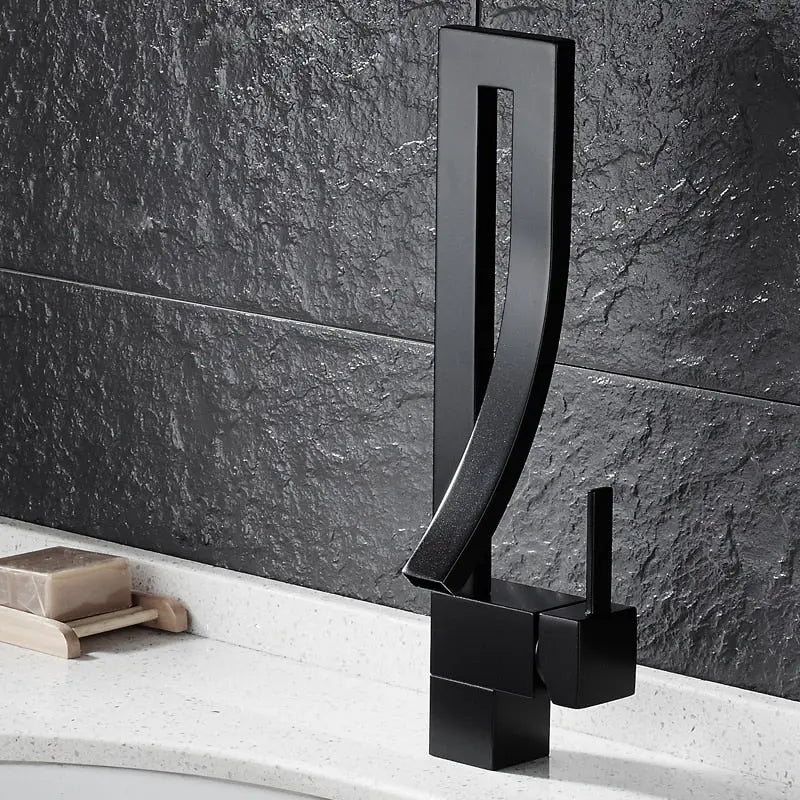 Black faucet on a bathroom sink with a dark tiled wall background