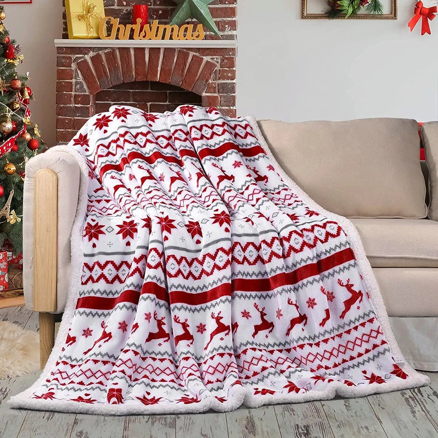 red and white flannel Christmas blanket with reindeer pattern on couch in festive living room
