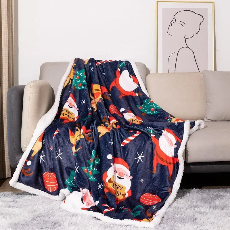 Double layer flannel Christmas blanket with Santa Claus and holiday prints on sofa