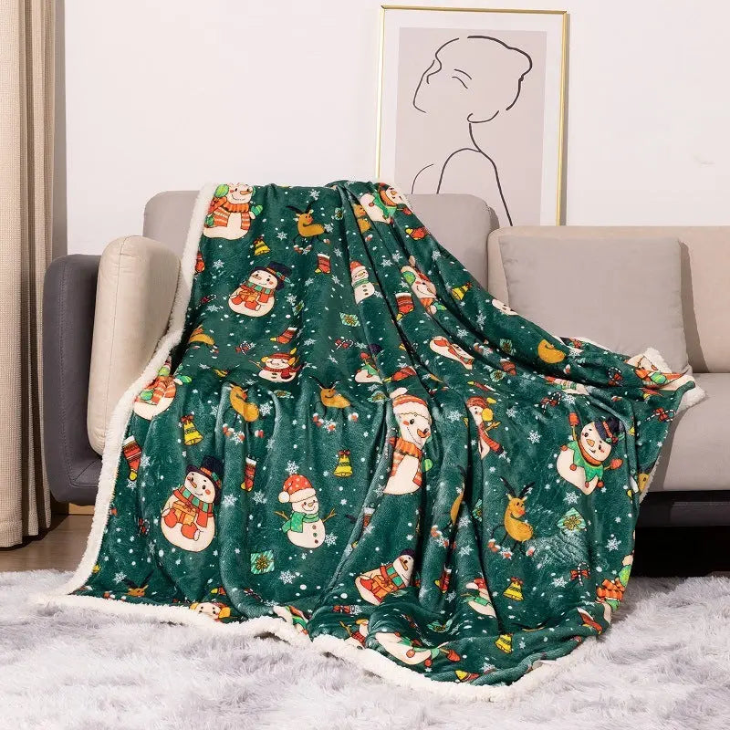 Green flannel Christmas blanket with snowman, reindeer, and Santa designs draped on sofa