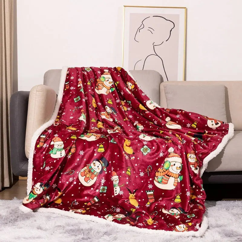 Red flannel Christmas blanket with snowman and festive holiday designs draped over sofa