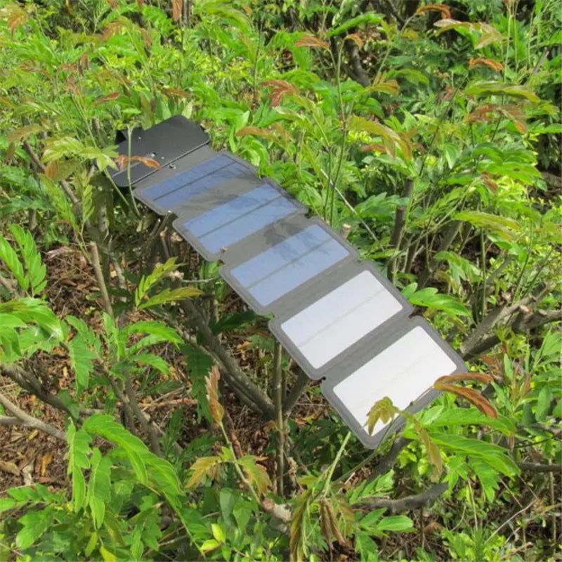 Outdoor folding solar panel charger with USB output for portable device power supply in nature setting