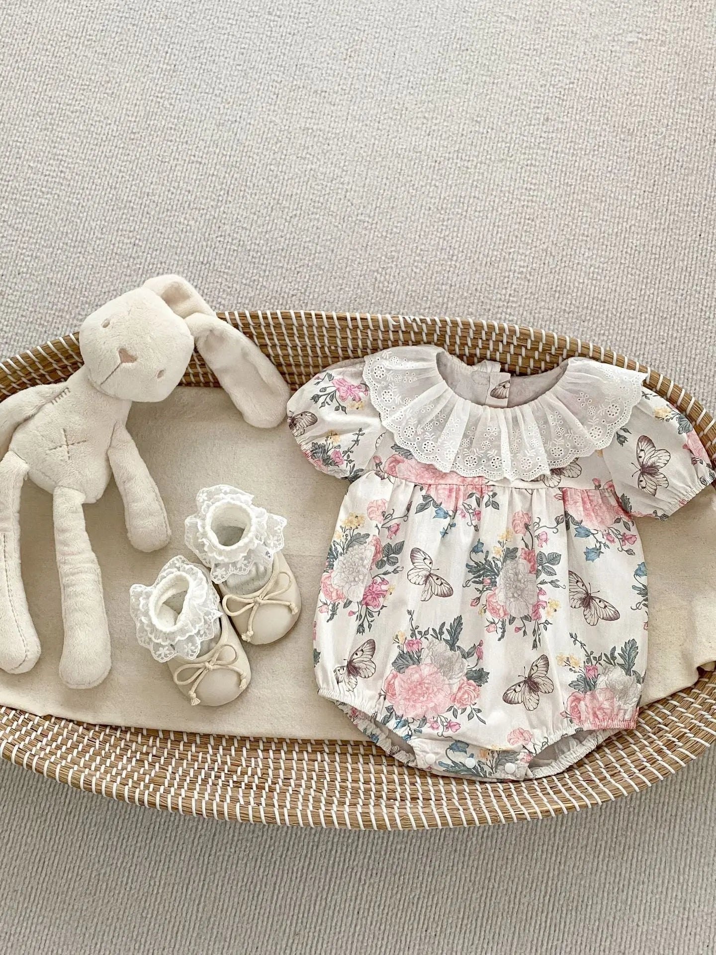 Vintage-style baby girls floral butterfly patterned short sleeve cotton onesie dress in pink and beige with lace collar and matching baby shoes.