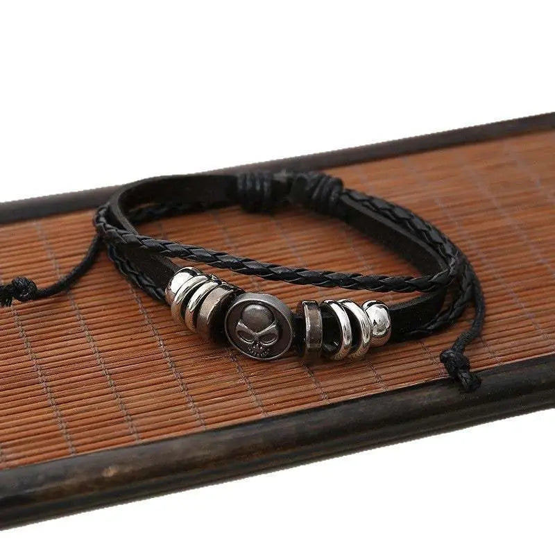 Black leather bracelet set with skull charm and silver alloy accents on woven straps