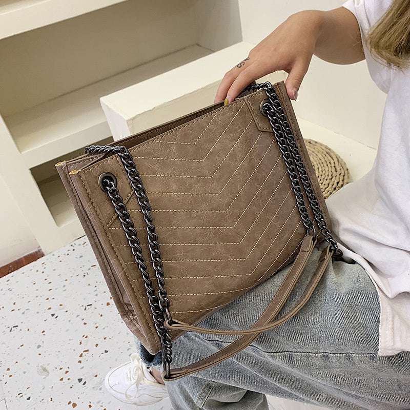 Ladies messenger bag in brown PU leather with chain shoulder straps and zipper closure