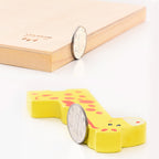 Yellow rubber stamp shaped like a cartoon character with a coin for scale on a light background