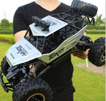 Green 4WD RC Car off-road buggy with large tires held by person