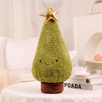 soft plush green Christmas tree pillow with gold star on top on white table