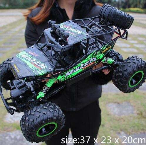 4WD RC Car off-road buggy with green and black design and large tires held outdoors