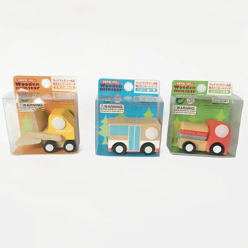 Three wooden toy vehicles in packaging on a white background