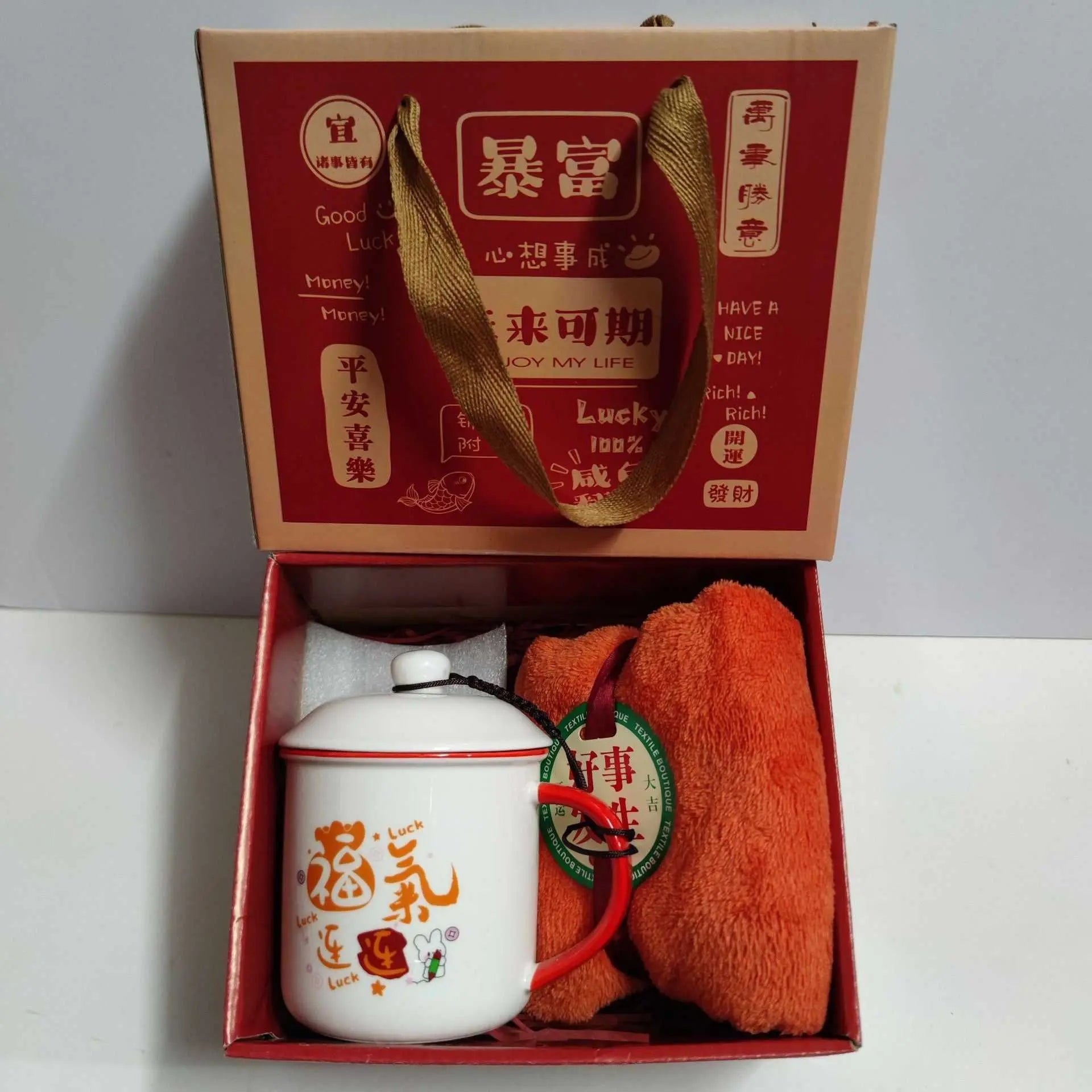 Ceramic cup gift box set with letter print mug, spoon, towel, and gift packaging in red and orange.