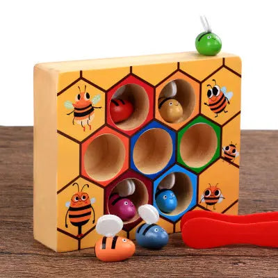 Wooden toy with honeycomb design and small animal figures on a wooden surface