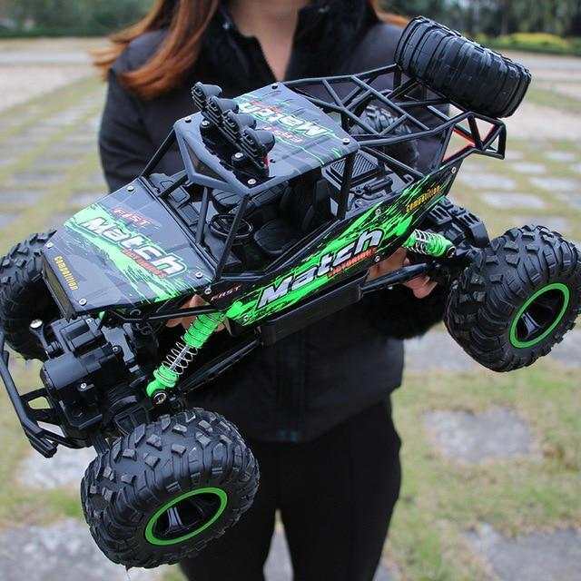 Green 4WD RC Car off-road buggy with rugged tires and metal frame held by person outdoors