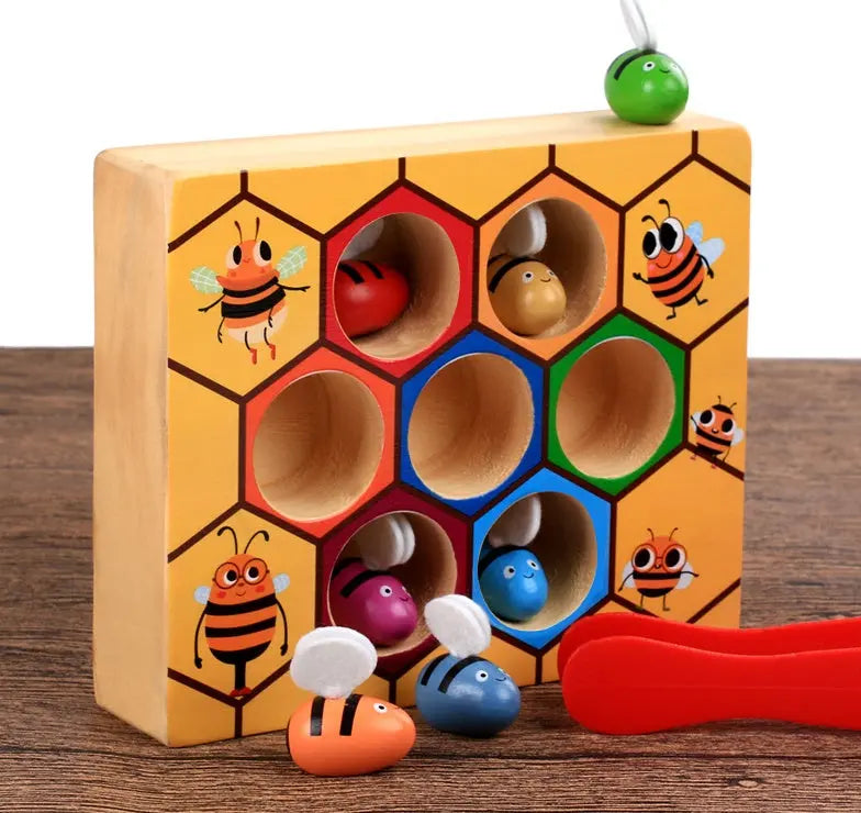 Wooden toy with honeycomb design and bee figures on a wooden surface