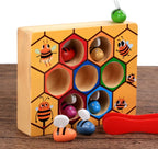 Wooden toy with honeycomb design and bee figures on a wooden surface