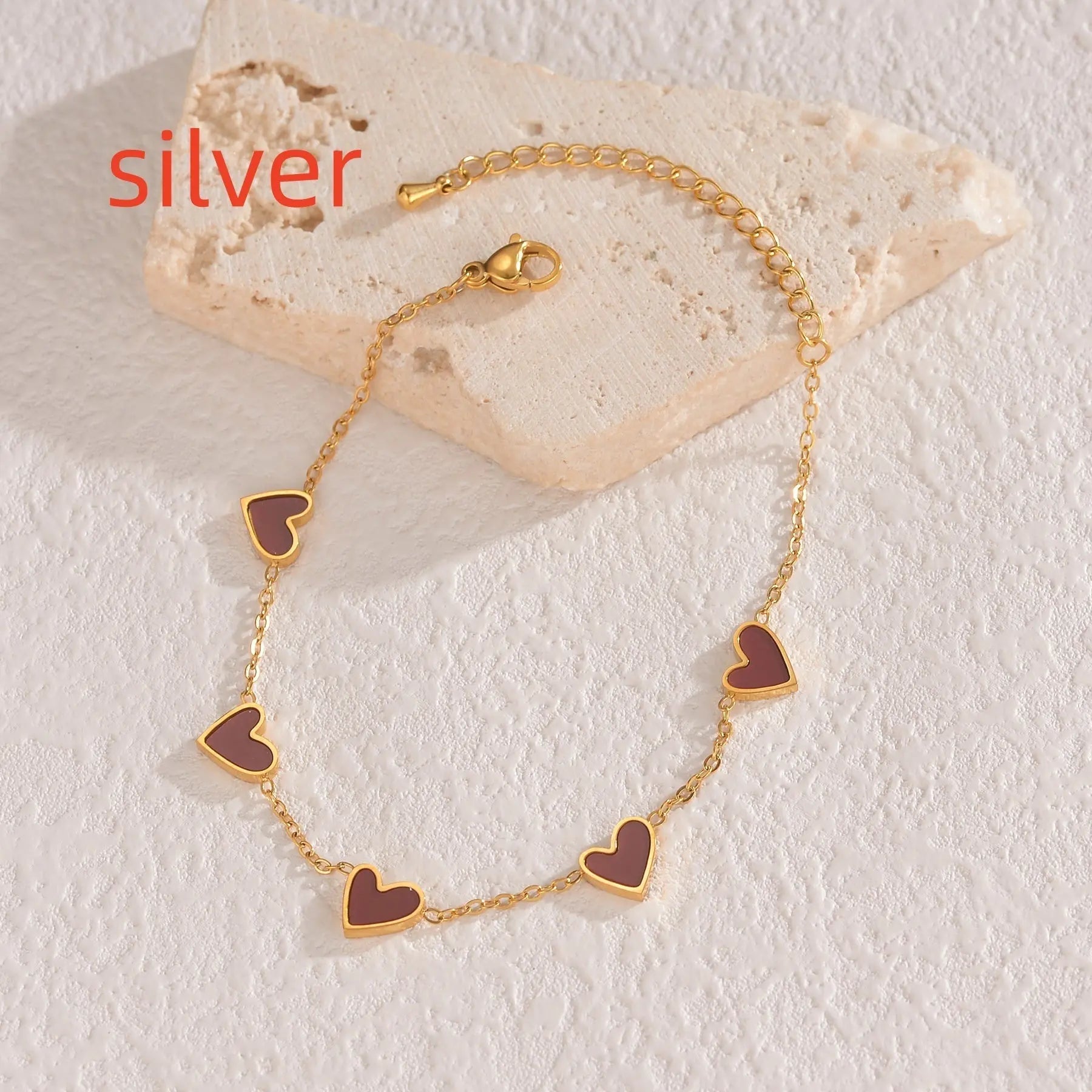Gold-colored love heart bracelet with multiple heart charms on a delicate chain