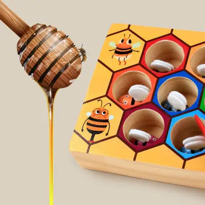 Wooden toy with honeycomb design and bee illustrations, accompanied by a wooden honey dipper.