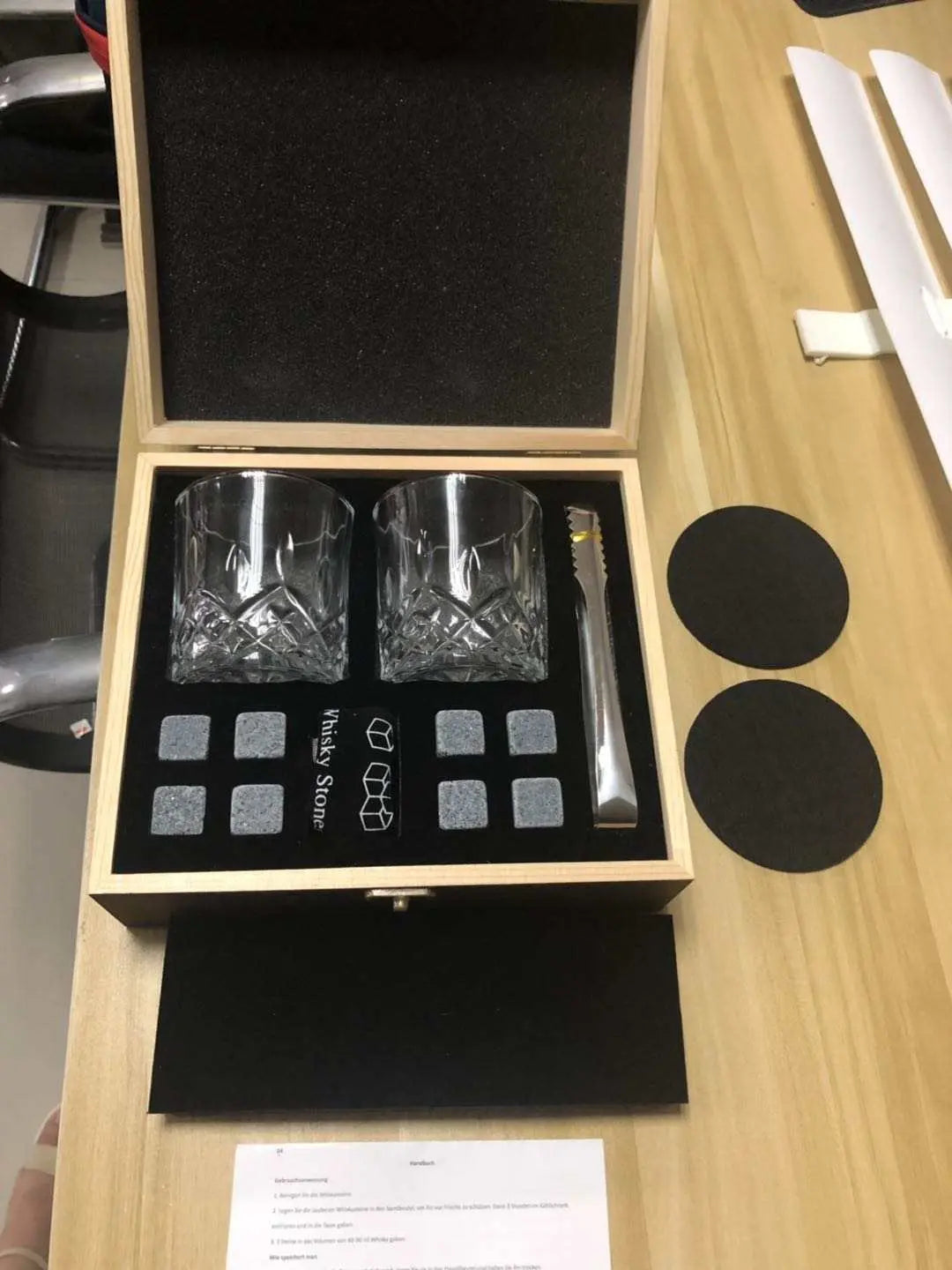 Whisky glasses and granite stones set in wooden gift box with tongs and black coasters for chilling drinks without dilution