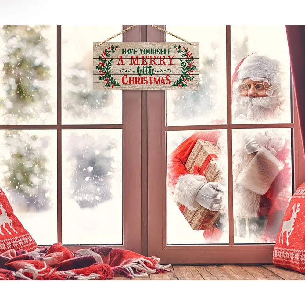 Christmas interior pendant with festive wooden sign hanging on window, showing "Have Yourself A Merry Little Christmas" text, with Santa Claus outside and cozy holiday decorations inside.