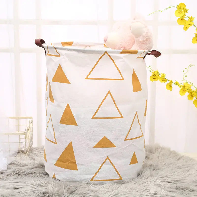 White laundry basket with gold triangle patterns on a fluffy surface with flowers in the background