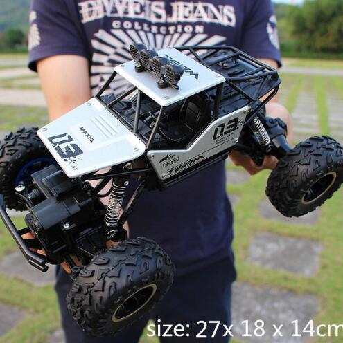 4WD RC Car off-road buggy with large tires held outdoors, scale 1:12, black and white design