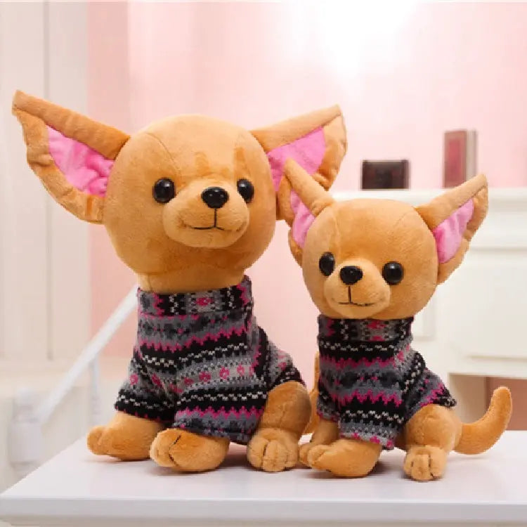 Two adorable plush dog doll toys wearing cozy patterned sweaters on a table