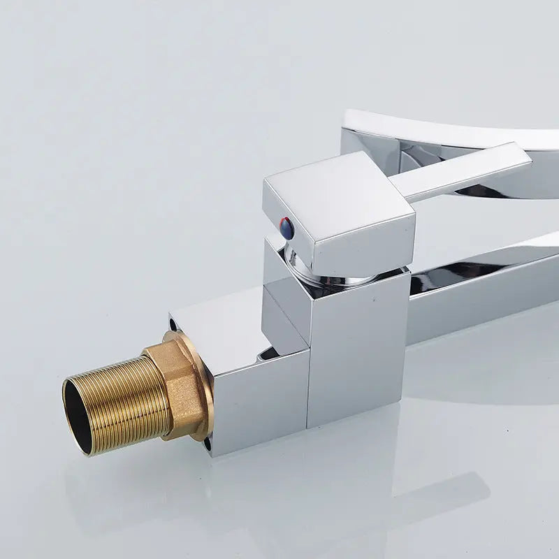 Chrome bathroom faucet with brass connection on a light gray background