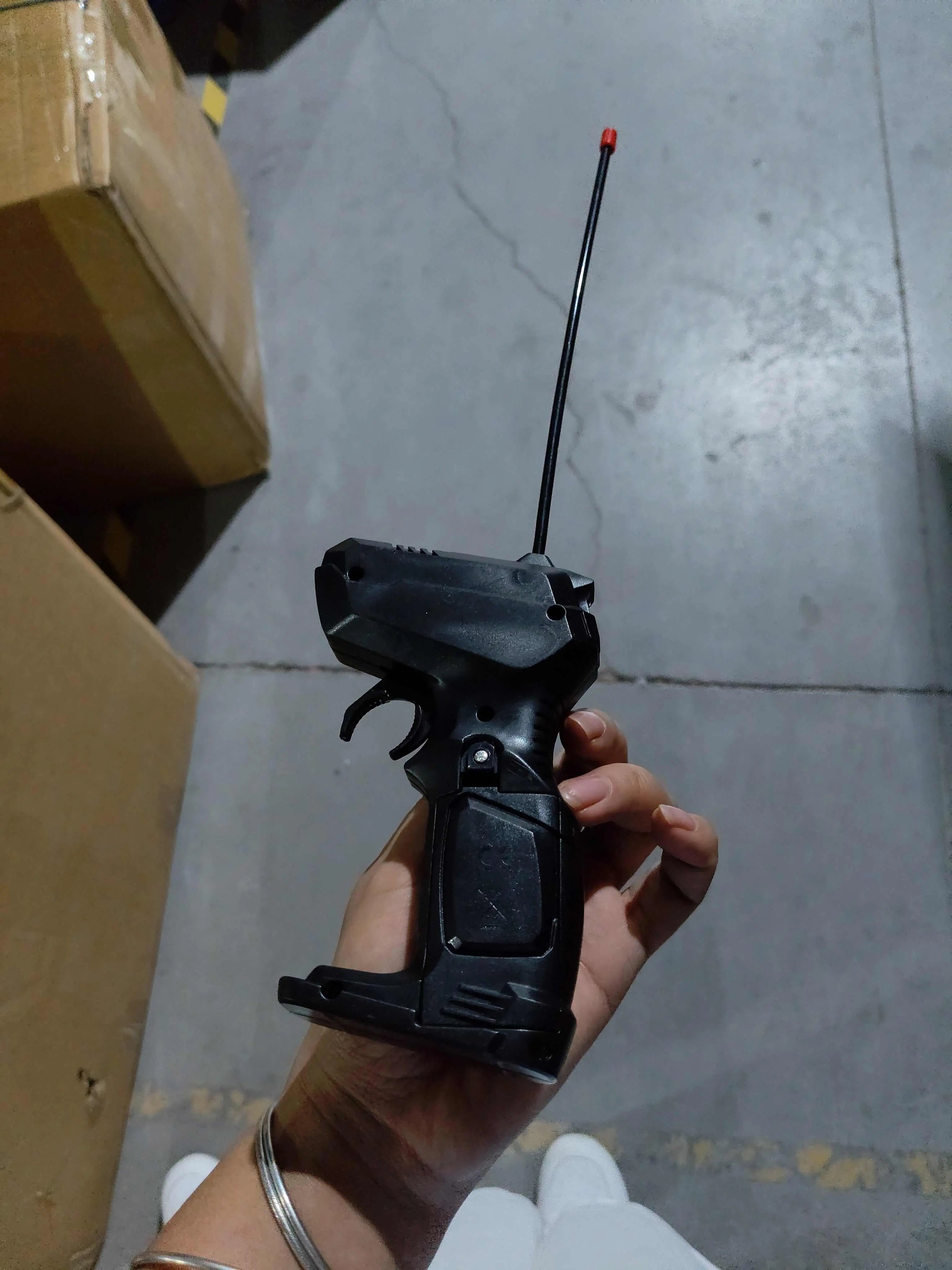 2.4G gun remote control for 4WD RC Car off-road buggy in hand on concrete floor background