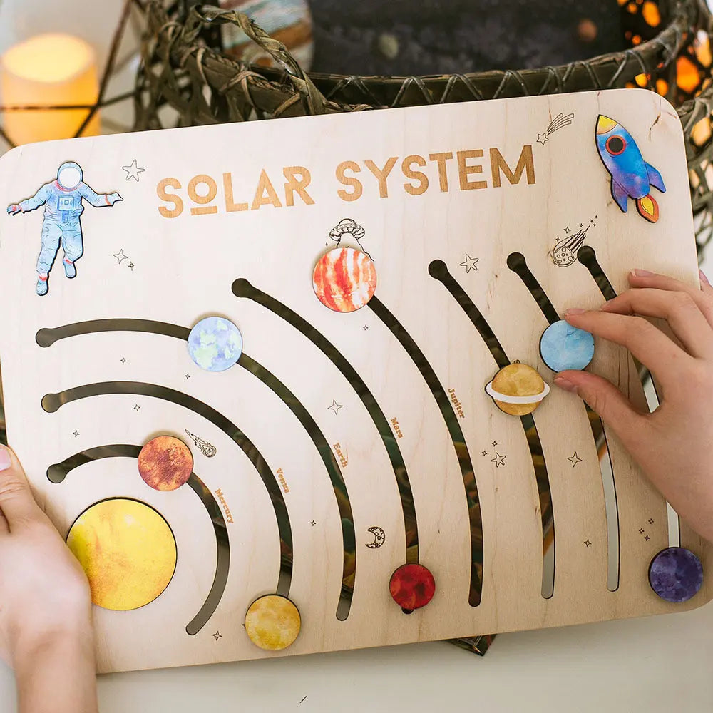 Children's educational toy with solar system design, featuring planets and a hand interacting with it.