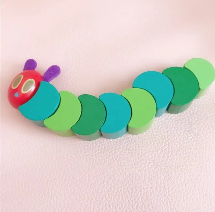 Colorful toy caterpillar on a pink background