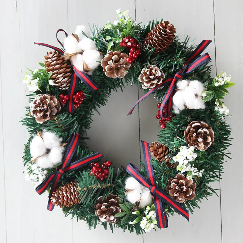 Christmas wreath hanging decoration with pinecones, cotton, red berries, and ribbon on green PVC garland